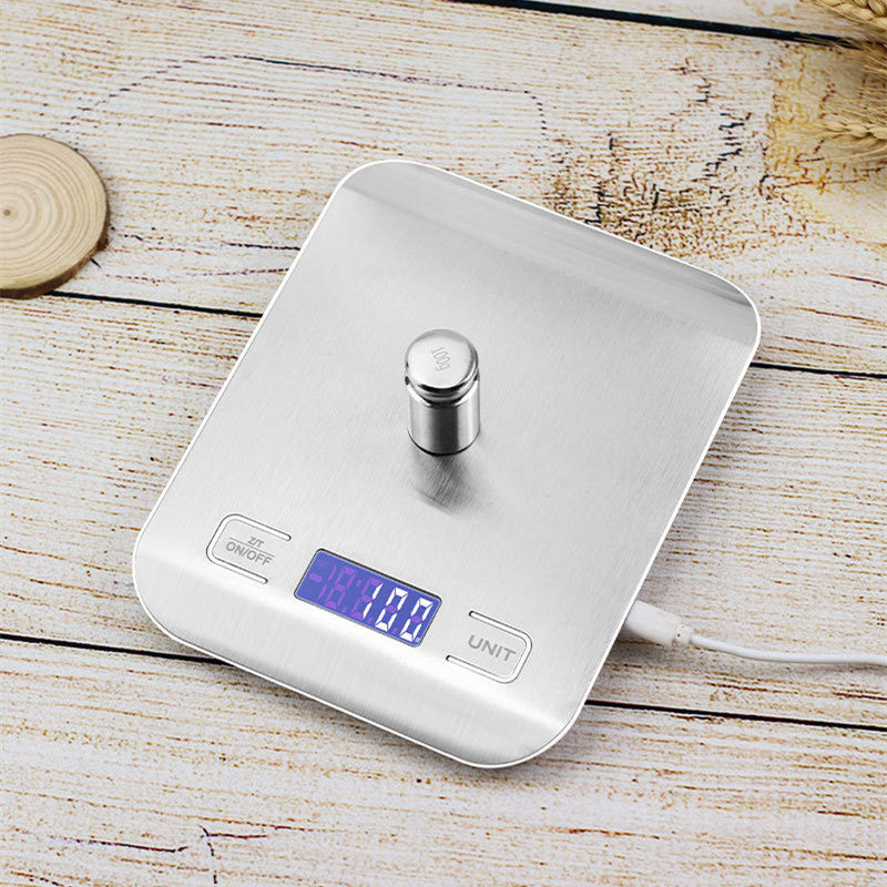 Kitchen Electronic Scale Household Food Baking Gram Measuring on wooden surface with LCD display.
