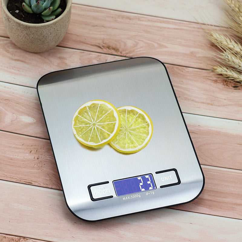 Kitchen Electronic Scale Household Food Baking Gram Measuring with lemon slices on a stainless steel surface.